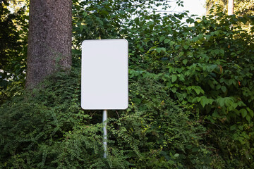 Empty blank sign board on a pole in a forest