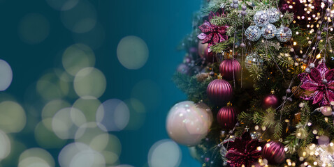 Magically decorated Christmas Tree with balls, ribbons and garlands on a blurred blue shiny, fairy and sparkling background.