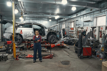 Female car mechanic standing in auto repair shop