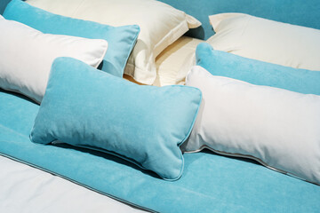 Fragment of a large bed with rectangular pillows. Aqua bedroom accessories. Close up