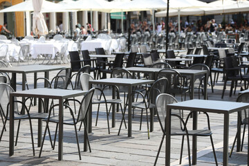 empty chairs and tables without customers in the alfresco restaurante in the square of European city during the economic crisis caused by the lockdowns