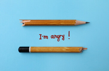 Broken pencil and inscription I'm Angry! on light blue background, flat lay