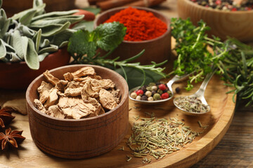 Different herbs and spices on wooden table, closeup
