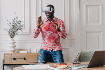 African man in VR headset interacting with digital interface, using innovative device for business