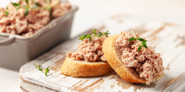 Fresh homemade goose liver pate on toasted bread with greens and capers.