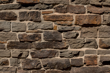 Fragment of the wall from brown flat natural stone