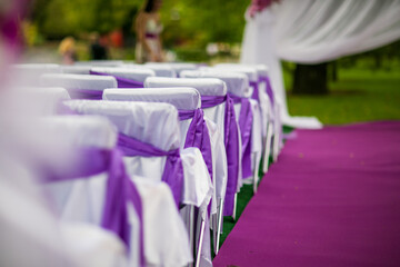 wedding ceremony in purple flowers chairs and walkway