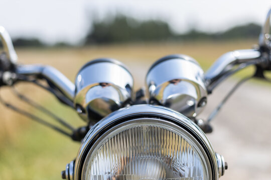 Frontansicht eines Motorrad mit Scheinwerfer auf dem Feldweg - Powered by Adobe