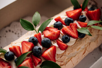 Top view on meringue roll dessert with berries