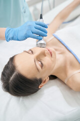 Obraz na płótnie Canvas Woman having anti-wrinkles facial treatment with radiofrequency device