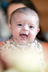 Laughing baby portrait indoors. Happy child, joyful and playing concept.