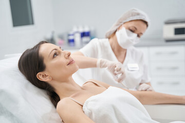 Obraz na płótnie Canvas Woman receiving rejuvenating injection in cosmetology clinic