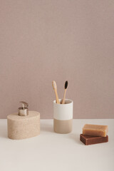 Vertical conceptual shot of modern ceramic bathroom accessories with toothbrushes and soap bars still life composition, copy space