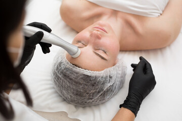 Close-up of the face of a young girl who does no-injection mesotherapy in a modern cosmetology...