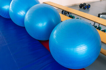 A big blue fitness ball in the gym. A large elastic ball for aerobics. Exercise ball. A ball for...