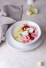 Cauliflower soup puree decorated with radish