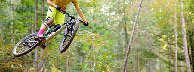 Homme saute avec un v&eacute;lo de descente dans la nature en for&ecirc;t - vtt sport extreme
