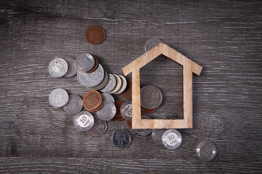 House And Coins On The Table