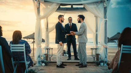 Handsome Gay Couple Exchange Rings and Kiss at a Beach Wedding Ceremony Venue at Sunset. Two Happy...