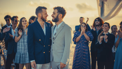 Portrait of a Happy Just Married Handsome Gay Couple Kissing. Two Attractive Queer Men in Suits Smile and Pose for Camera with Diverse Friends. LGBTQ Relationship and Family Goals.