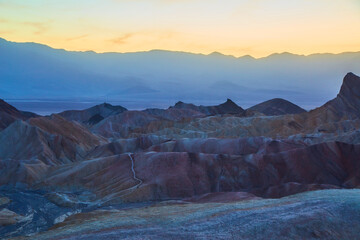 Dusk golden light hitting colorful mountains in Death Valley