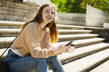 A female blogger uses her phone to write a message on a social network.