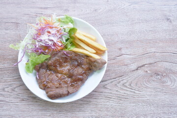 grilled black pepper pork steak with french fries and salad dressing mayonnaise on plate