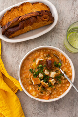 Soup with barley and sauerkraut, a plate with soup and croutons, top view on the table with food, delicious healthy lunch, Russian cuisine