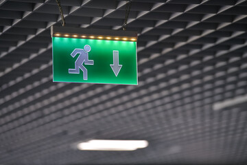 Emergency exit sign on the ceiling of a new modern office company. Corporation headquarters safety...
