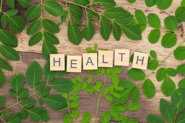 green moringa leaf background with health writing using wooden blocks