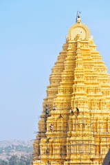people woking on high golden indian temple