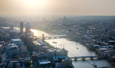 City of London at sunset. View include modern skyscrapers, banks and office buildings, river Thames, London bridge.