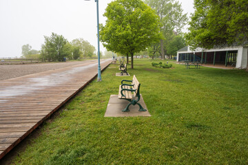 A wooden boardwalk and an empty beach on a foggy afternoon in Toronto's Beaches neighbourhood shot...