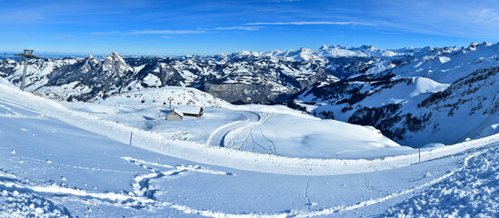 Snowed ski slopes and mountain ridges in Swiss Alps. Top of the glacier panorama. Switzerland.

