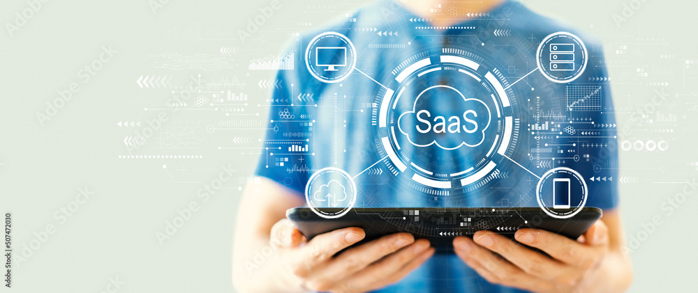 Poster saas - software as a service concept with young man using a tablet computer