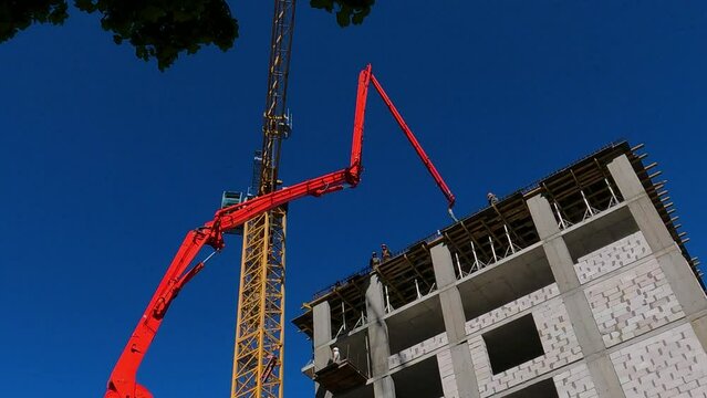 Construction site of a multi-storey residential building, a concrete pump truck delivers cement to a height