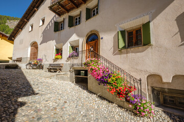 The village of S-Chanf in the Upper Engadine Valley (Grisons, Switzerland), has a gorgeous historic center with stone houses and flower decorations. The river Inn flows through the village.