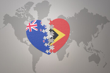 puzzle heart with the national flag of new zealand and east timor on a world map background. Concept.