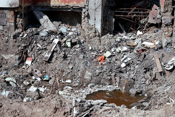 Explosion of an air bomb near the entrance of a residential building. A large crater from an aerial bomb next to a residential high-rise building