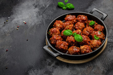 Meatballs with tomato sauce in frying pan on dark background, Long banner format. top view