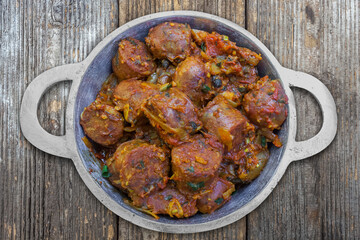 Rougail de saucisses dans petite marmite et sur table de pique-nique 