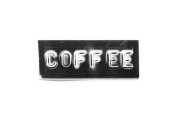 Black color banner that have embossed letter with word coffee on white paper background