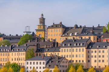 Old houses on a hill in the district Södermalm with tin roofs and dorms a sunny summer day in...