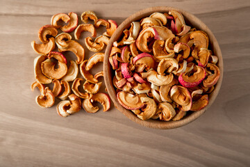 Bowl full of dried apples on a wooden background