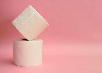 two stacked toilet paper and pink background