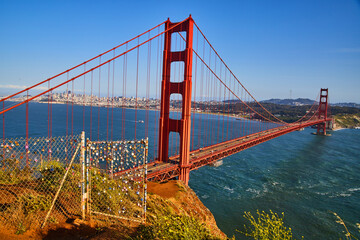 Fence covered in locks next to Golden Gate Bridge at Sunset