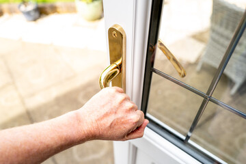Home owner seen opening a newly installed double glazed back door, leading to a patio area and rear...
