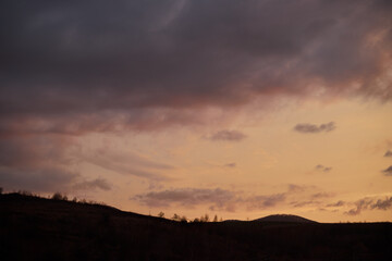 Panoramic view of clouds over mountains silhouette.