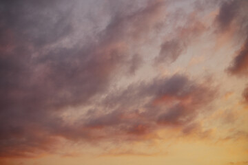Full frame of beautiful sky with clouds at sunset in warm colors.