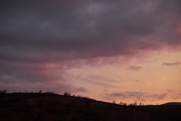 Panoramic view of clouds over mountains silhouette.